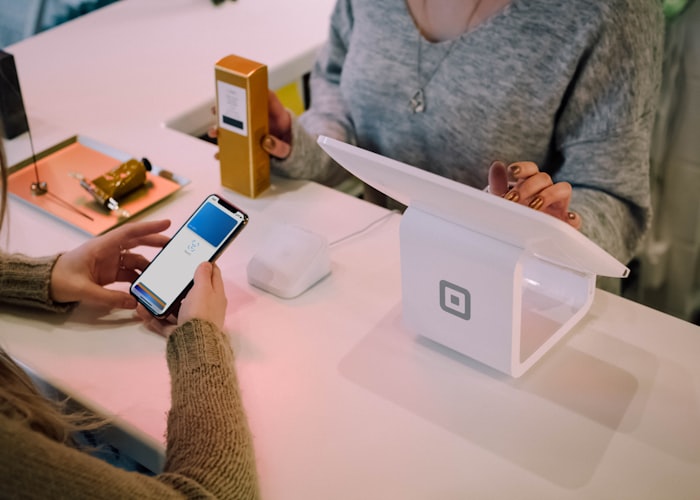 Entrepreneur taking a mobile payment at a small business counter
